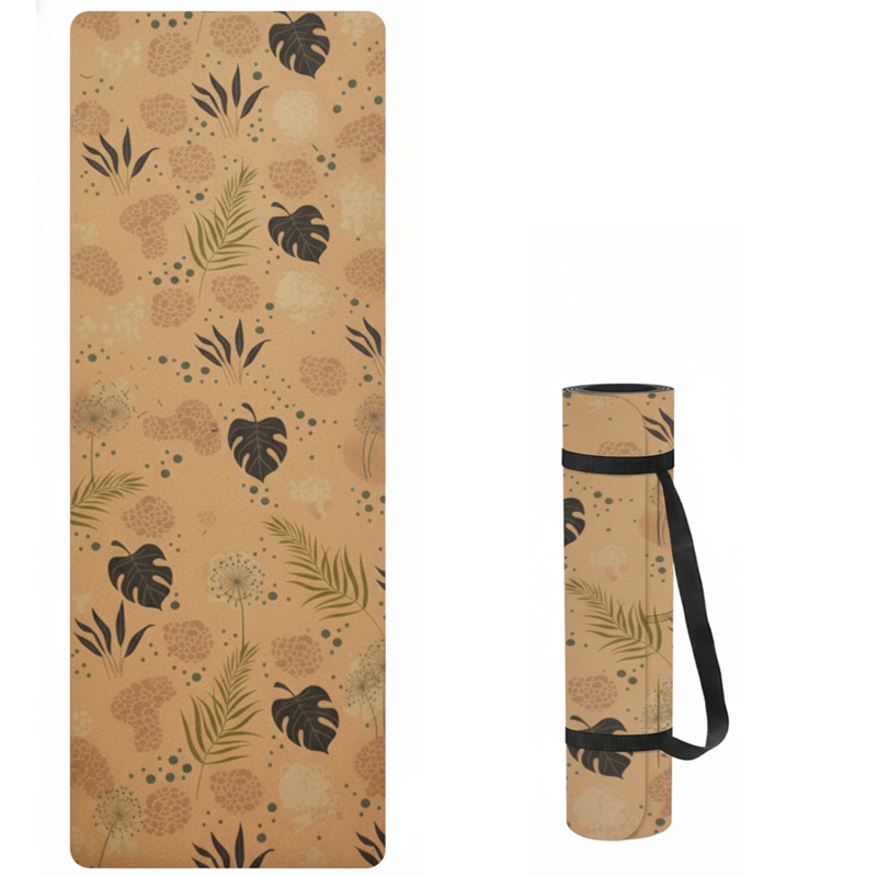 A natural cork yoga mat with a green and black botanical leaf pattern, shown laid out flat and also rolled up with a black carrying strap.
