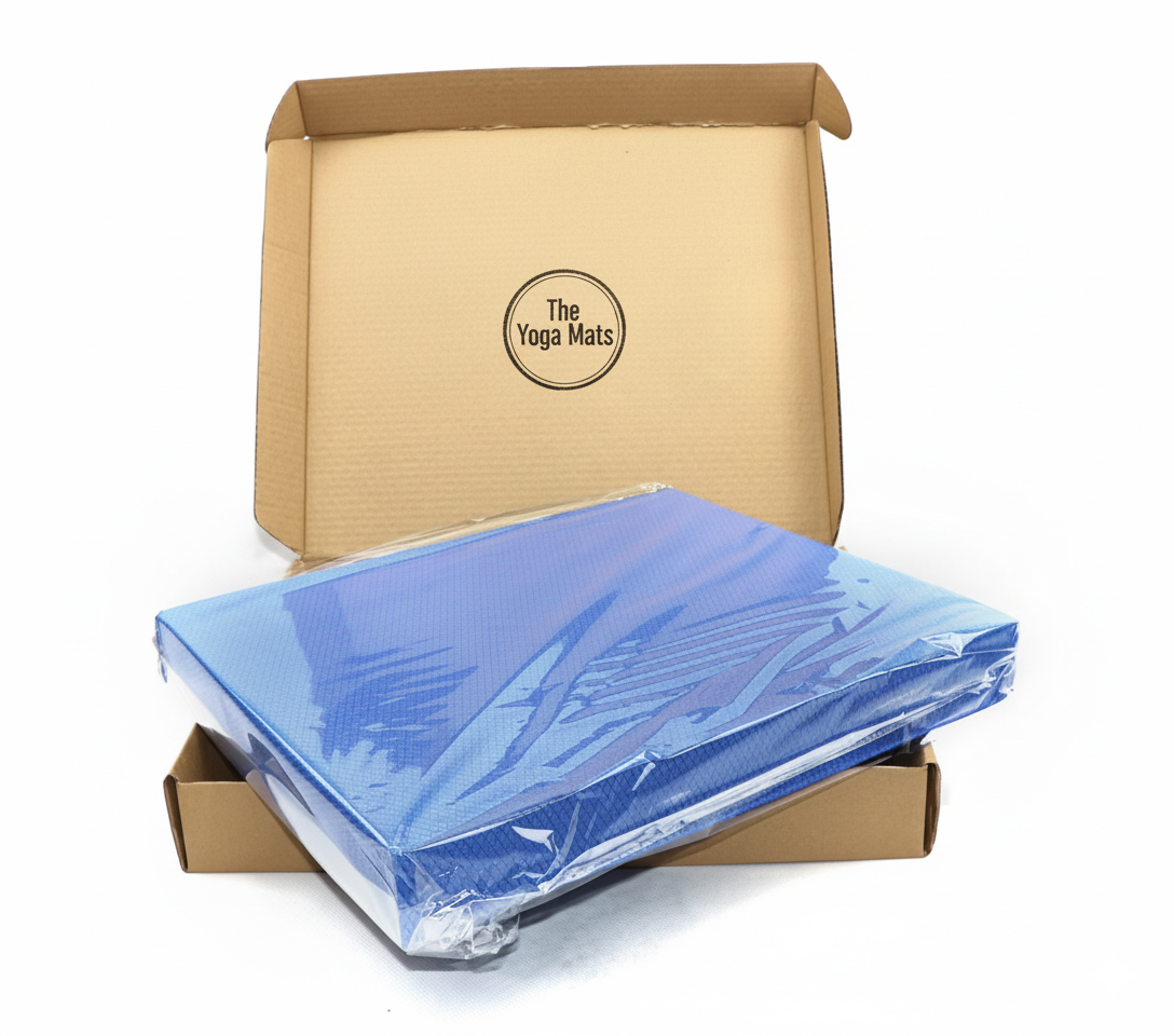 A blue foam pad being packaged into a custom box with the client's logo "The Yoga Mats", highlighting our OEM/ODM capabilities for custom branding and packaging.