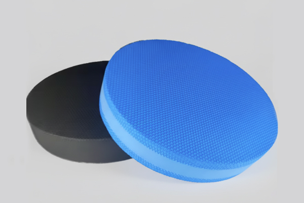 A close-up of a blue and a black round high-density TPE foam balance pad, perfect for sports rehab and fitness training.