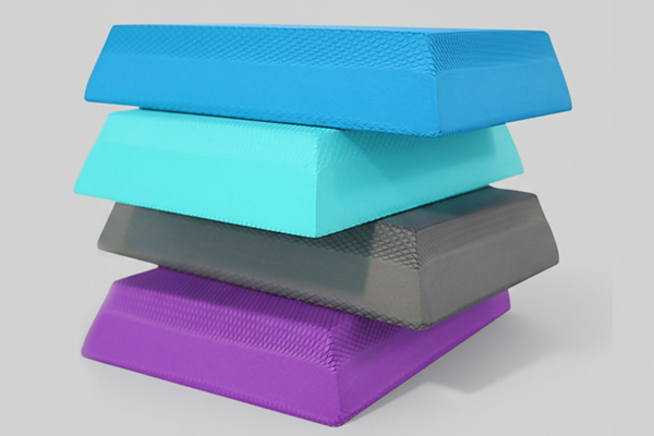 A stack of five colorful TPE foam yoga bricks in various colors including blue, grey, and purple, ideal for versatile training applications.